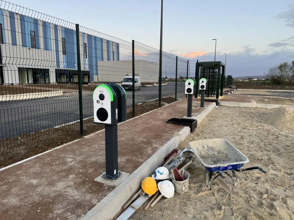 Bornes de recharge en cours d'installation devant un bâtiment tertiaire