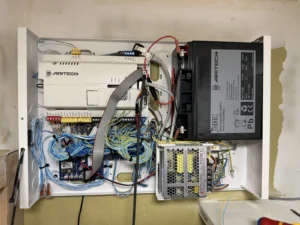 Centrale intrusion Aritech avec alimentation secourue et batterie dans son coffret