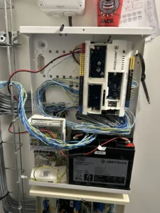 Centrale intrusion Aritech câblée dans son coffret avec batterie de secours