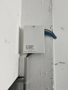 Coffret technique E2F Solutions fixé au mur avec son câblage apparent