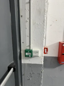 Déclencheur vert de demande de sortie installé près d'une porte de secours
