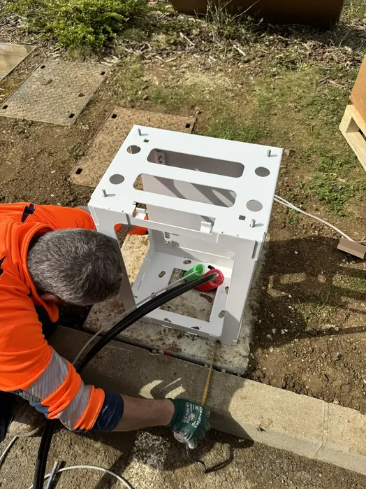 Technicien E2F Solutions posant le socle d'une borne de recharge sur massif béton